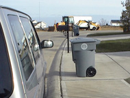 Vehicle blocking access to trash cart.
