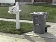 Trash cart adjacent to mailbox.