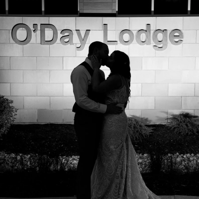 Bride and groom share a kiss in front of O'Day Lodge
